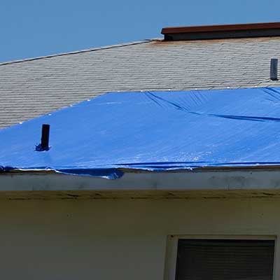 Blue tarp on a residential roof as a temporary fix for storm damage